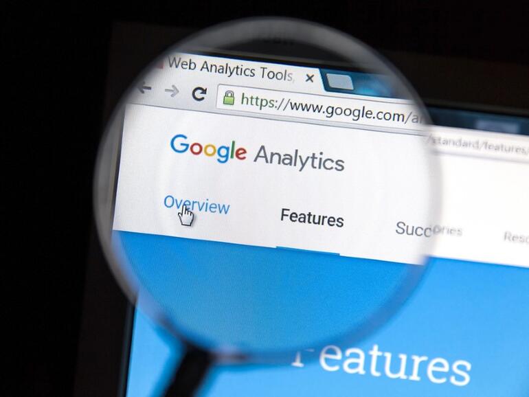 Google Analytics website under a magnifying glass. Google Analytics is a web analytics service offered by Google.