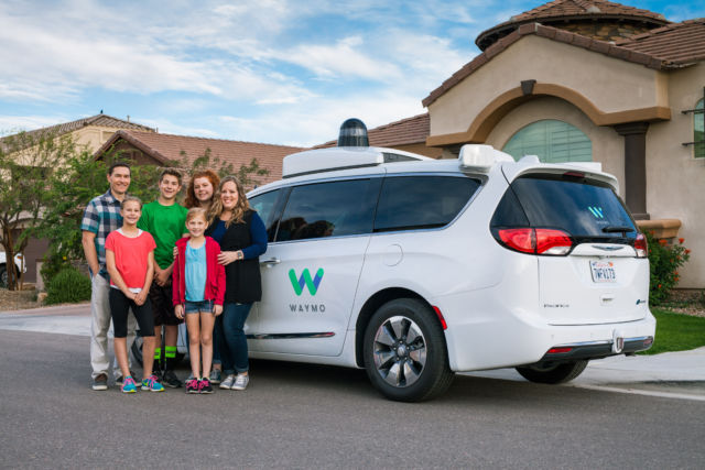 One of the earliest families in Waymo's public trial in Phoenix poses with a Waymo minivan.