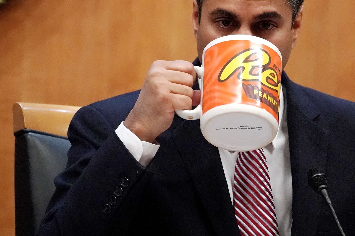 Federal Communications Commission Chairman Ajit Pai drinks from a big coffee cup during a commission meeting December 14, 2017 in Washington, DC. 