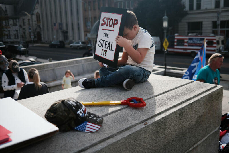 HARRISBURG, PENNSYLVANIA - NOVEMBER 05: A child holds a sign as dozens of people calling for stopping the vote count in Pennsylvania due to alleged fraud against President Donald Trump gather on the steps of the State Capitol on November 5, 2020 in Harrisburg, Pennsylvania. The activists, many with flags and signs for Trump, have made allegations that votes are being stolen from the president as the race in Pennsylvania continues to tighten in Joe Biden's favor. 