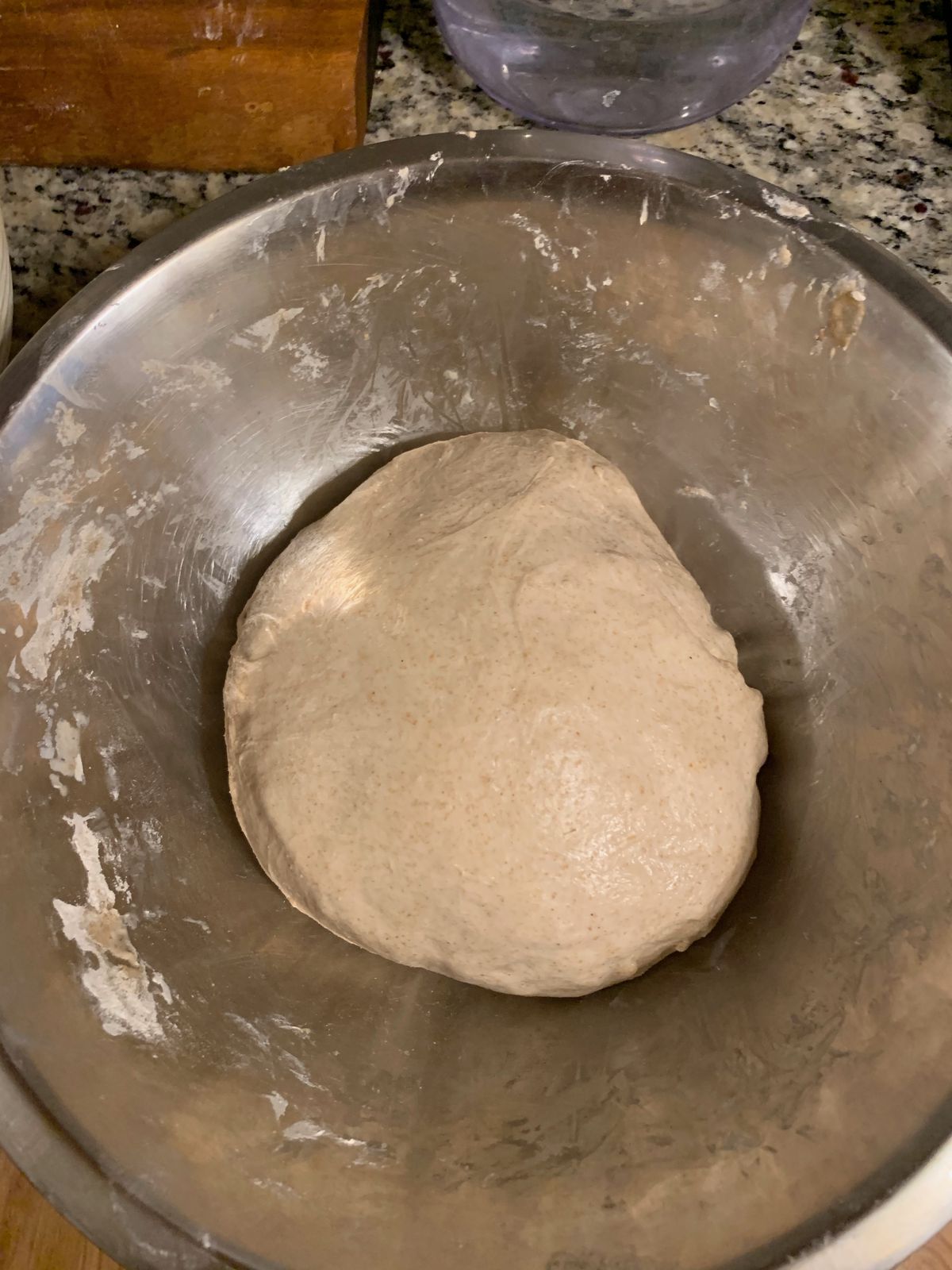 Bread dough in a metal bowl.