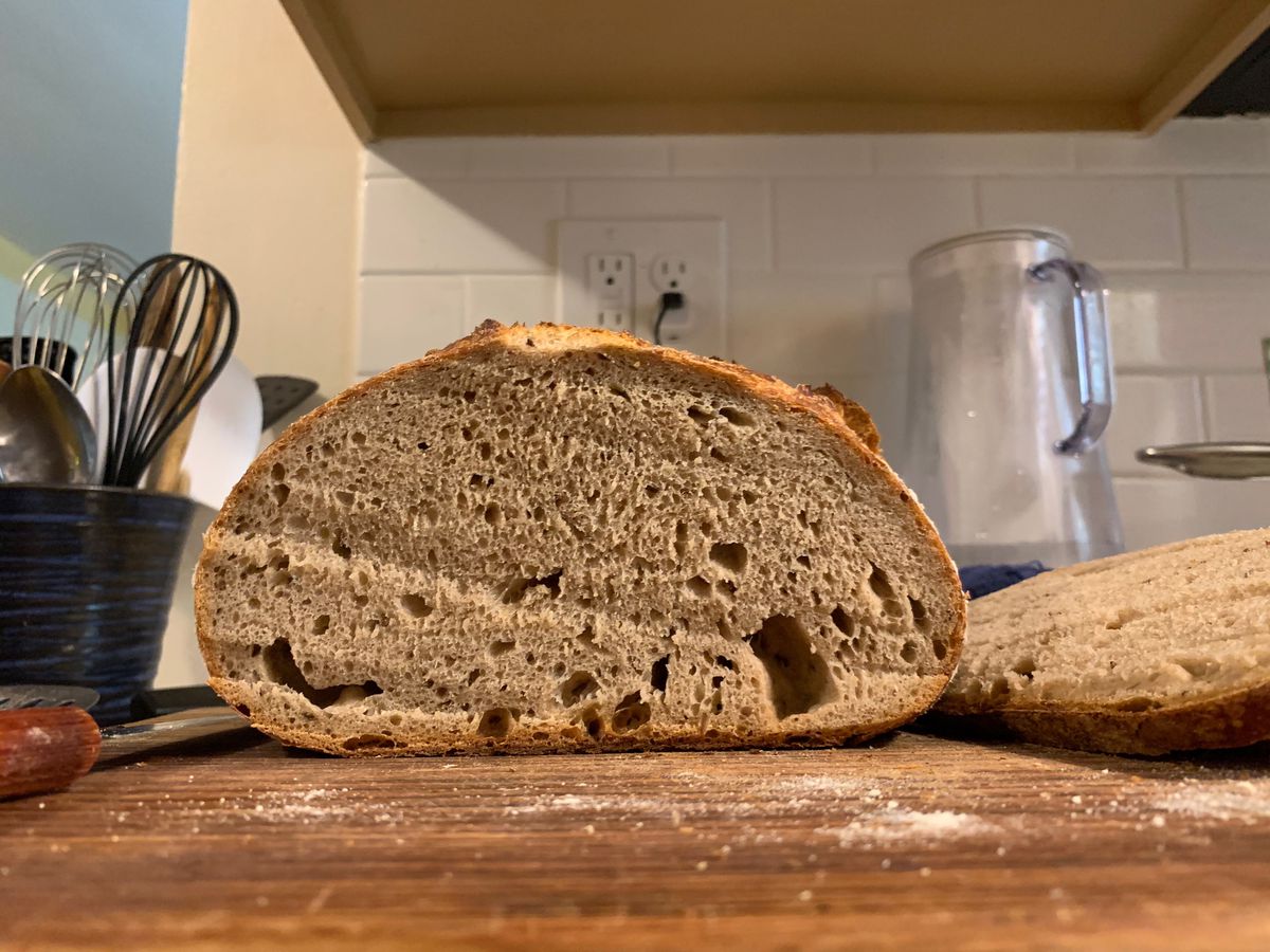 A cross-section of a loaf of bread sitting on a cutting board.