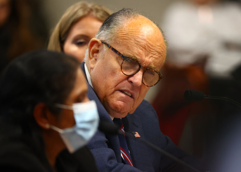 US President Donald Trump's personal attorney, Rudy Giuliani, listens to Detroit poll worker Jessi Jacobs during an appearance before the Michigan House Oversight Committee on December 2, 2020 in Lansing, Michigan.